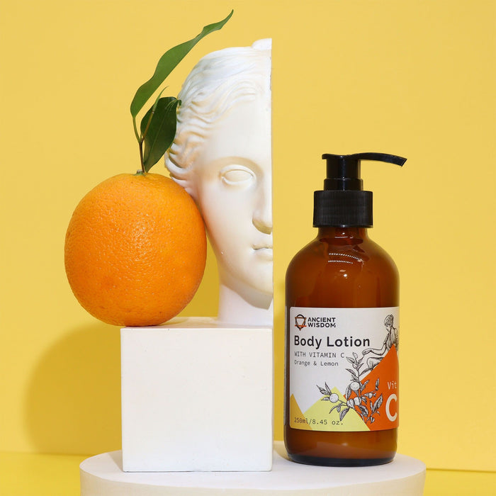 The Window, Milford Haven Vitamin C Goddess body lotion in a pump bottle with orange and lemon, next to a statue bust.
