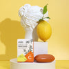 The Window, Milford Haven Vitamin C hand soap bar with citrus essential oils next to a lemon and classical bust statue.