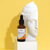 The Window, Milford Haven Goddess’s Glow Vitamin C face serum in an amber glass bottle next to a white bust sculpture.