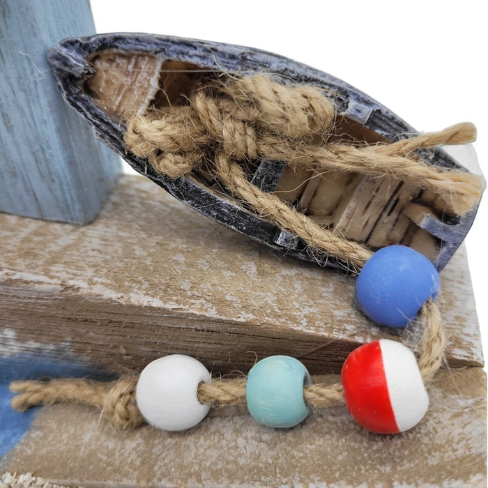The Window, Milford Haven wooden coastal ornament featuring a miniature boat with rope and colorful fishing floats