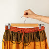 The Window, Milford Haven wooden clip hanger holding orange patterned trousers with adjustable metal clips