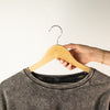 The Window, Milford Haven natural wooden clothes hanger with metal hook holding a grey acid-wash t-shirt