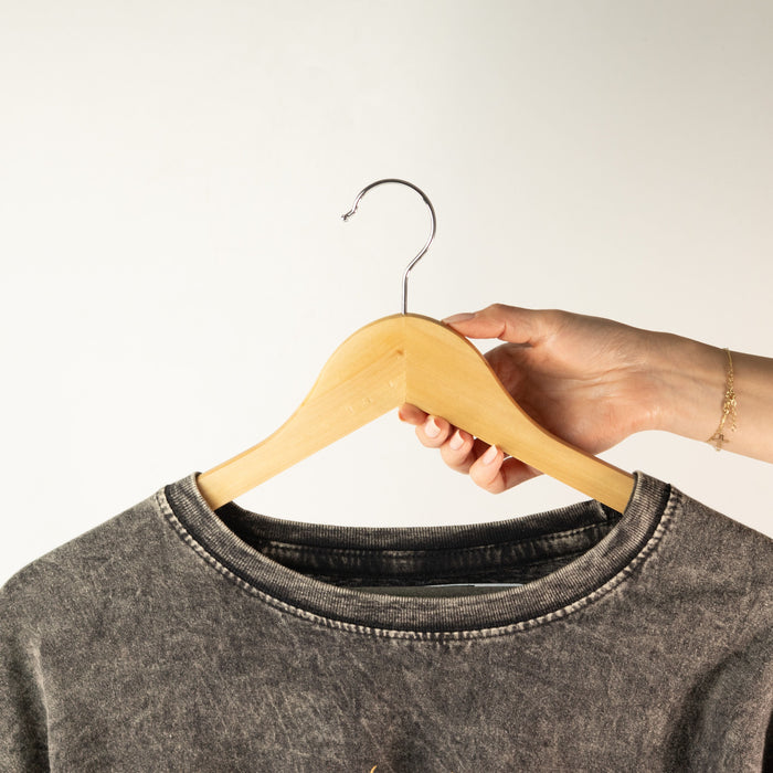 The Window, Milford Haven natural wooden clothes hanger with metal hook holding a grey acid-wash t-shirt