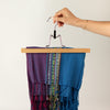The Window, Milford Haven wooden grip bar hanger holding a colourful patterned scarf in a hand