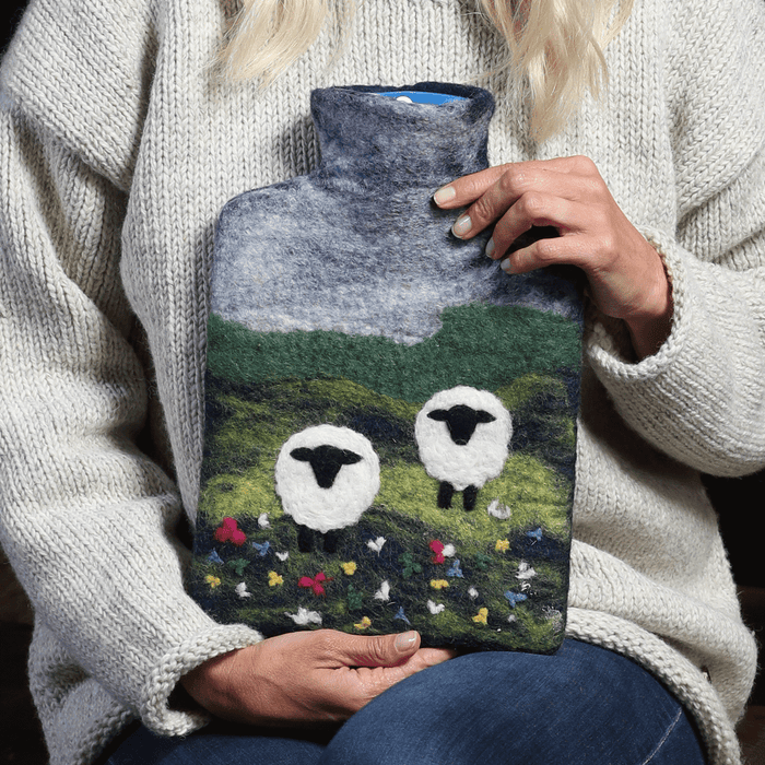 The Window, Milford Haven handmade wool felt hot water bottle featuring a sheep and countryside landscape design.