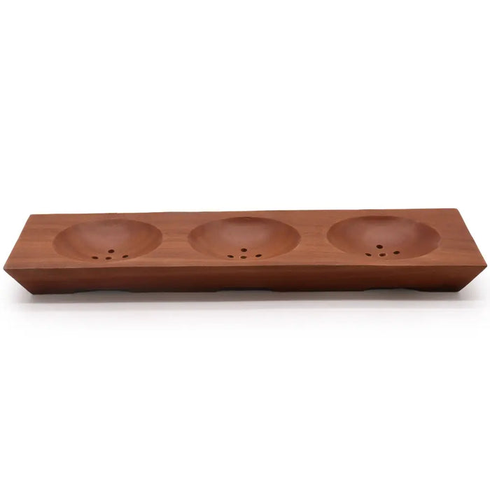 A sleek rectangular naseberry wood soap dish with three rounded basins and small drainage holes in natural wood
