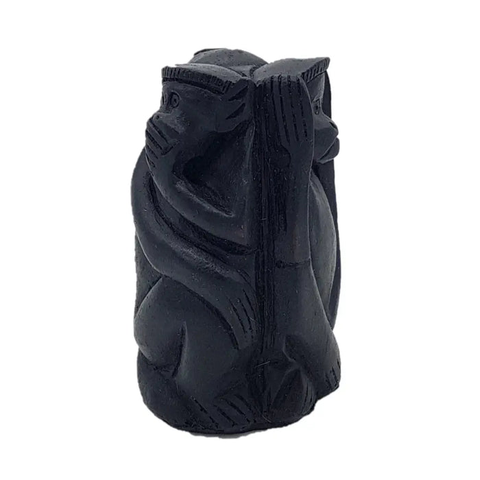Black carved wooden figurine of three wise monkeys with hands covering eyes ears and mouth in one design