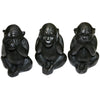 Three wise black wooden carved monkeys figurines showing see no evil hear no evil and speak no evil poses