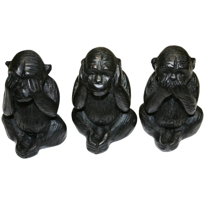 Three wise black wooden carved monkeys figurines showing see no evil hear no evil and speak no evil poses