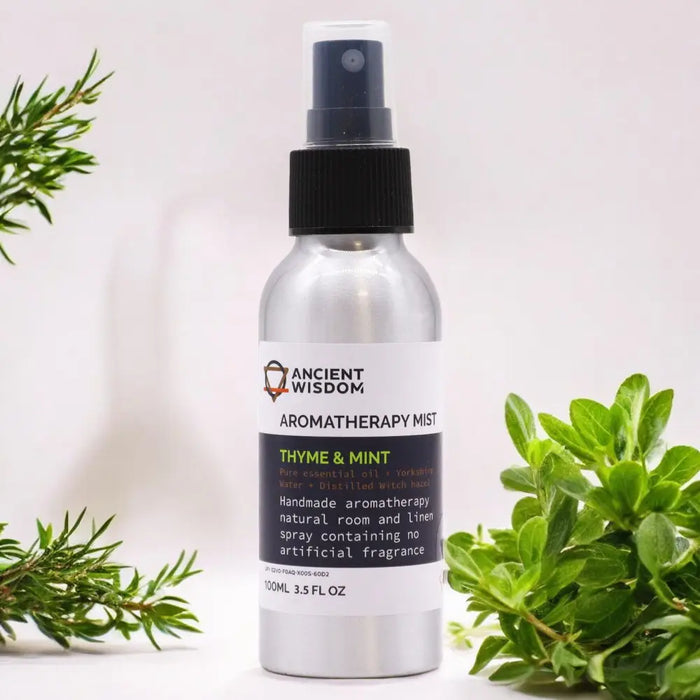 A sleek silver spray bottle with black nozzle labeled ancient wisdom aromatherapy mist thyme essential oil diffuser blend