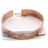 A copper wide copper tibetan mantra bracelet with an open-ended design and engraved leaf pattern inside