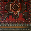 Traditional afghan mushwani rug in rich red and dark brown wool with white black and tan geometric patterns