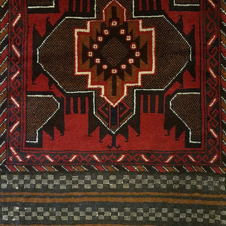 Traditional afghan mushwani rug in rich red and dark brown wool with white black and tan geometric patterns