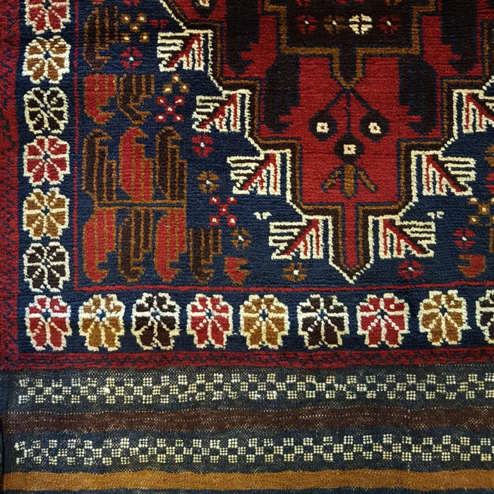 Traditional afghan mushwani rug with deep red navy blue fields and cream wool geometric motifs kilim-ended