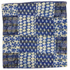A traditional blue kantha patchwork cushion cover with blue and white fabric squares and yellow stitching seams