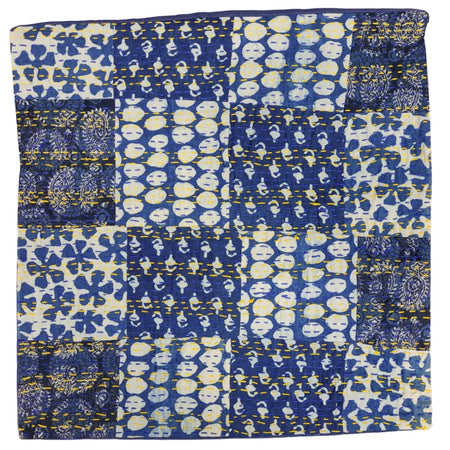 A traditional blue kantha patchwork cushion cover with blue and white fabric squares and yellow stitching seams