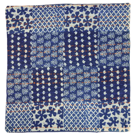 A traditional blue kantha patchwork cushion cover with stitched floral and geometric fabric squares and orange thread details