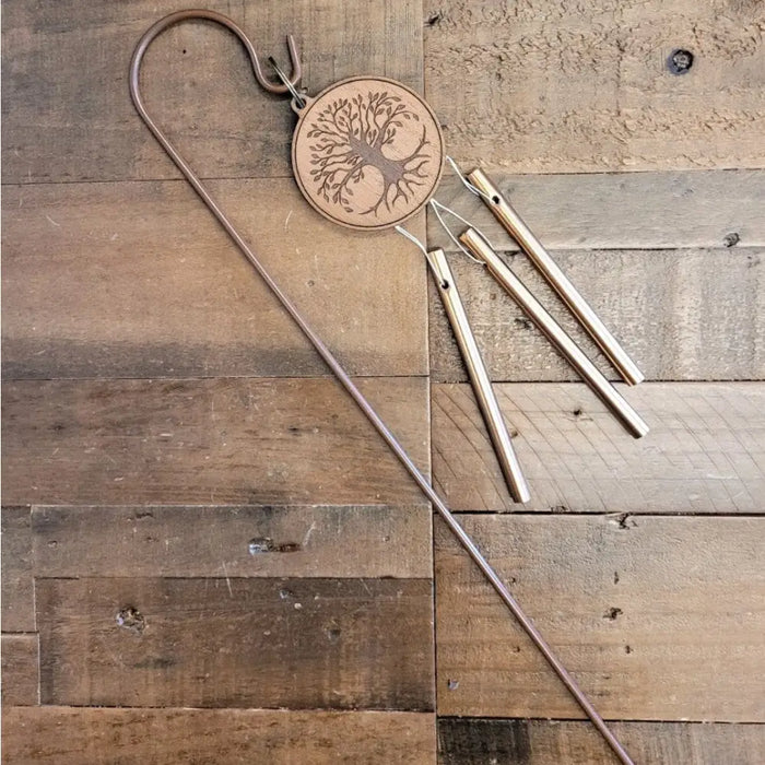 A rustic wooden medallion garden windchime with a laser-engraved tree design and three copper-coloured tubes