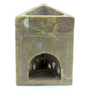 A carved green jade incense burner shaped like a triangular soapstone oil burner with dragon motifs and an arched opening