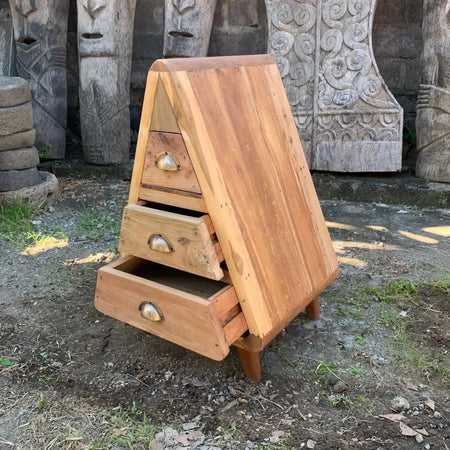 A rustic triangular wooden side table with three drawers and brass handles for home decor made from recycled wood