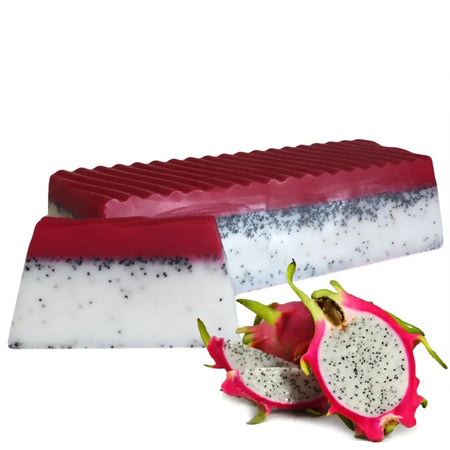 A rectangular soap loaf with a red dragon fruit top layer and white base speckled with black seeds has tropical fruit scents