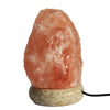 A warm pink usb himalayan salt lamp with a smooth translucent surface and earthy base showing hygroscopic properties