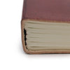 A rich burgundy vegetable tanned leather notebook with textured cover and neatly stacked off-white pages with strap