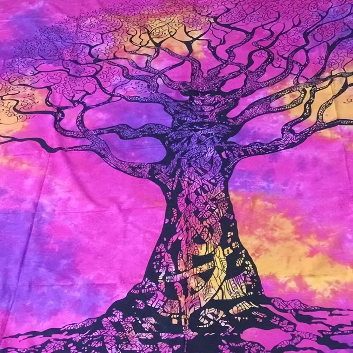 A vibrant tie dyed wall tapestry featuring a stylized black tree with roots on a pink purple orange background