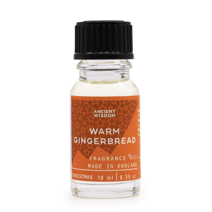 A clear glass bottle with black cap holds warm gingerbread fragrance oil labeled ancient wisdom with allergen declarations