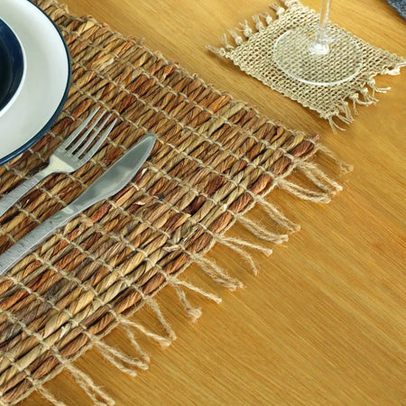 Natural woven water hyacinth placemat in earthy brown and tan made from twisted fibers for table setting