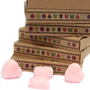 Pink heart-shaped erasers alongside red dragon’s blood wax melts made from palm waxes in a simple flat lay