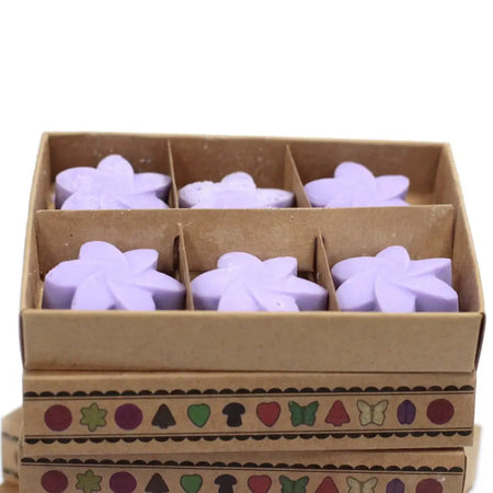 Lavender-colored flower-shaped palm waxes wax melts in a rustic cardboard box with decorative patterned trim