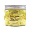 A clear glass jar with a silver lid holds pale yellow whipped soap scented with banana weighing 120g