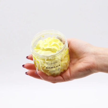 A clear glass jar with pale yellow banana-scented whipped soap in 120g size
