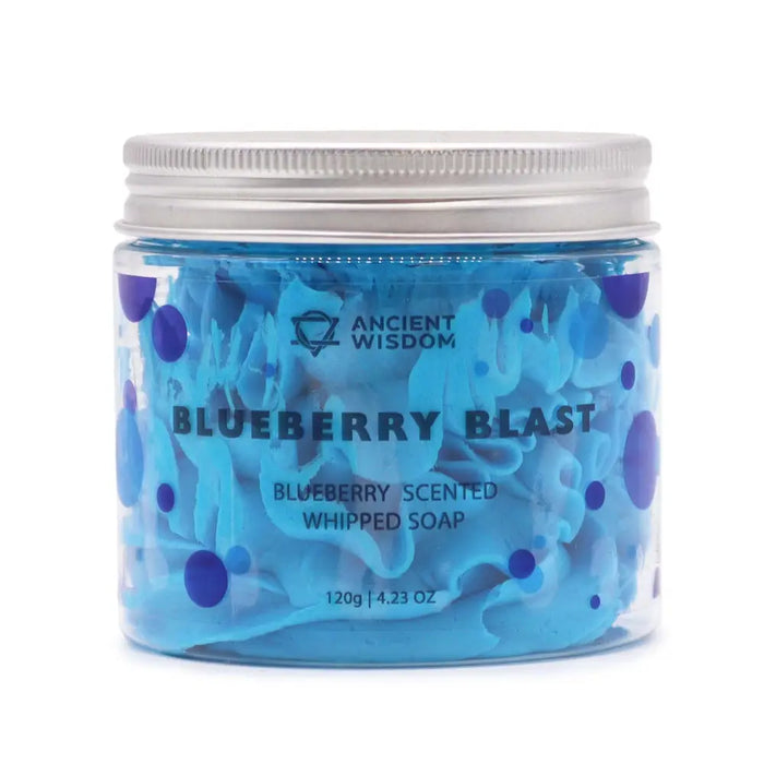 A clear glass jar with silver lid holds vibrant blue whipped soap speckled with purple dots labeled blueberry blast