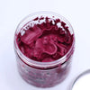 A clear glass jar filled with deep red ruffled whipped soap for gentle cleansing and moisturizing skin care