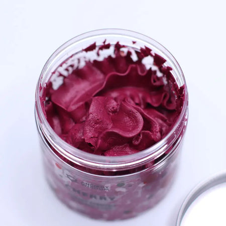 A clear glass jar filled with deep red ruffled whipped soap for gentle cleansing and moisturizing skin care