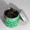 Emerald green glass jar with black polka dots holds dark purple glittery emerald truffle whipped soap from dubai