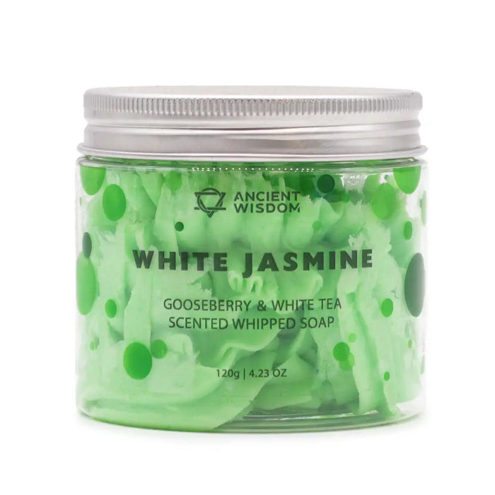 A clear glass jar with silver lid holds light green whipped soap with white tea and gooseberry swirls and dots