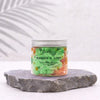A vibrant green and orange mango and lime scented whipped soap in a clear glass jar with silver lid from Ancient Wisdom