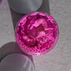 A vibrant pink charlotte whipped soap with glitter and ruffled texture sits inside a clear glass jar with peel oil