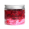 A vibrant pink and red razzle dazzle whipped soap in a clear glass jar with silver lid by ancient wisdom