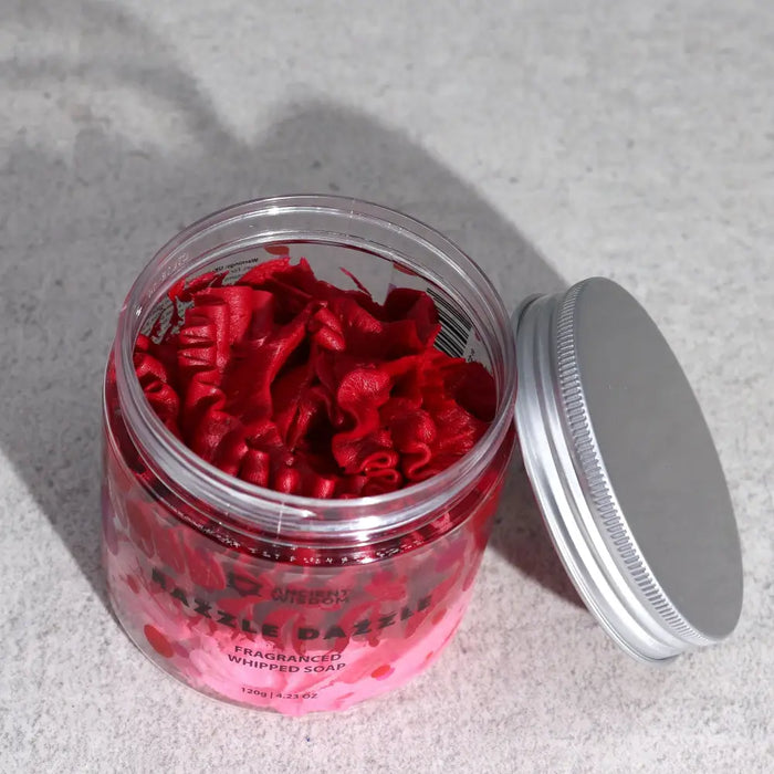 A clear glass jar with silver lid filled with vibrant red ruffled whipped soap razzle dazzle 120g