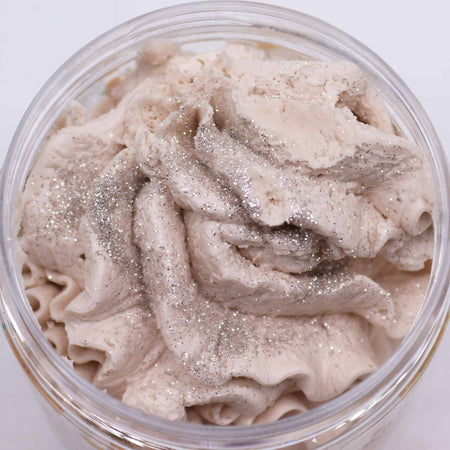 A creamy light beige whipped soap with a warm gingerbread scent and silver glitter in a clear plastic jar