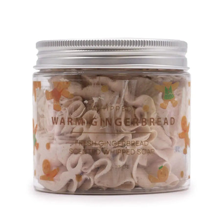 Clear jar with silver lid holding light beige whipped soap shaped like gingerbread cookies warm gingerbread scent