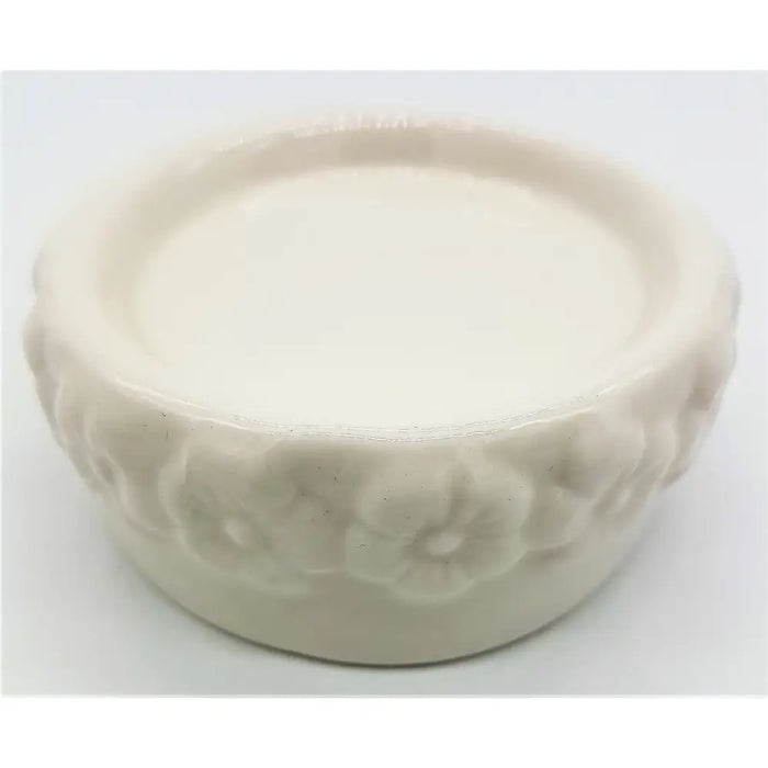 White ceramic candle stand with a floral embossed pattern around the rim made of ceramic material