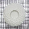 White ceramic tealight holder with a textured woven pattern around the rim made of white ceramic material