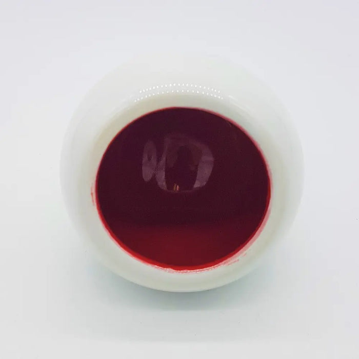 A white ceramic tealight holder bowl filled with deep red liquid from the traffic lights three colour options set