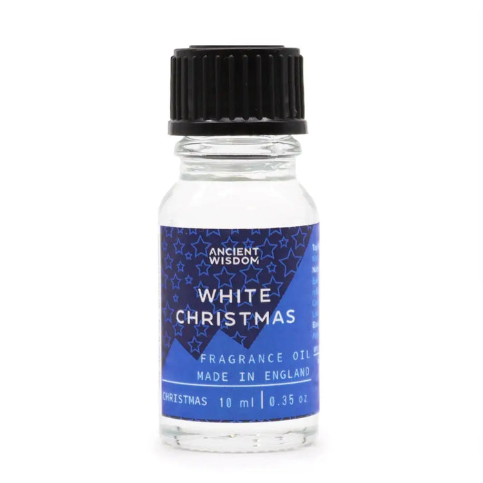 A clear glass bottle of white christmas fragrance oil with a black cap and blue label featuring stars and mountains