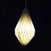 A warm cream-colored paper pendant light with a geometric faceted design in a white origami pendant shape